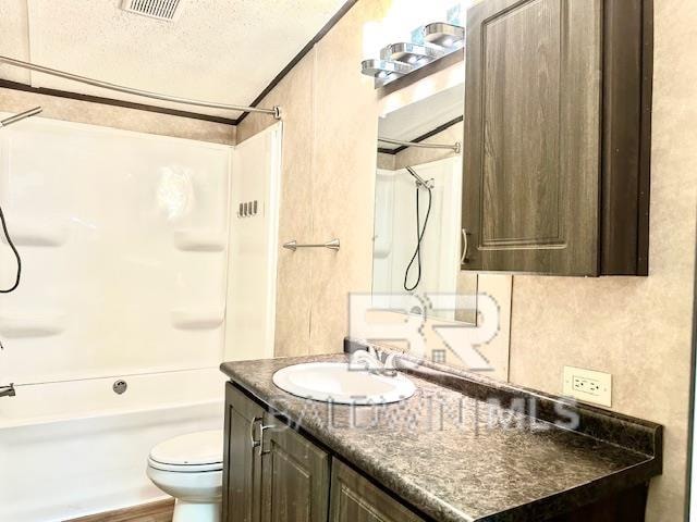 full bathroom with vanity, toilet, a textured ceiling, and bathing tub / shower combination