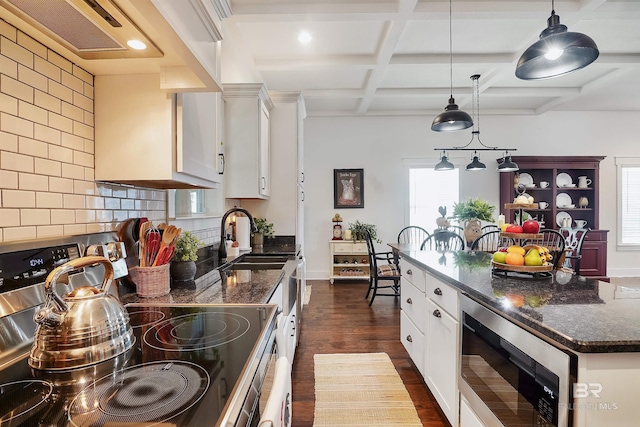 kitchen featuring stainless steel appliances, hanging light fixtures, sink, and white cabinets