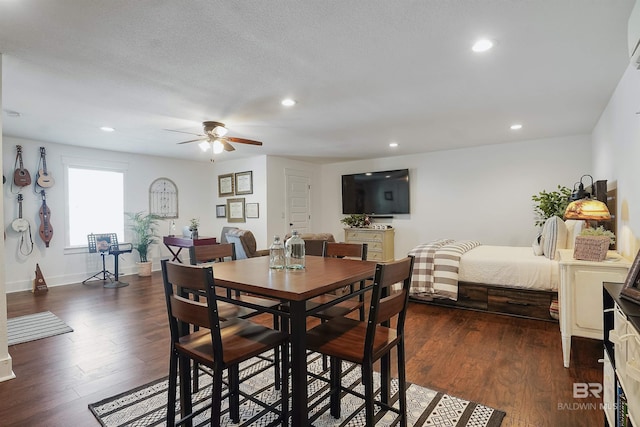 dining area featuring ceiling fan, dark wood-type flooring, and a textured ceiling