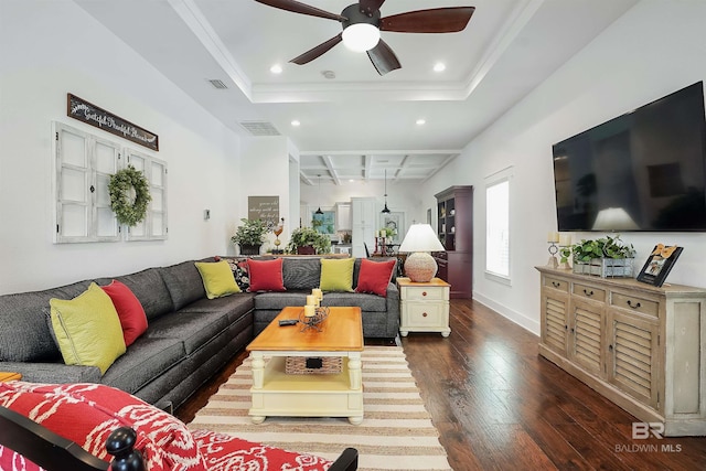 living room with crown molding, a tray ceiling, dark hardwood / wood-style floors, and ceiling fan