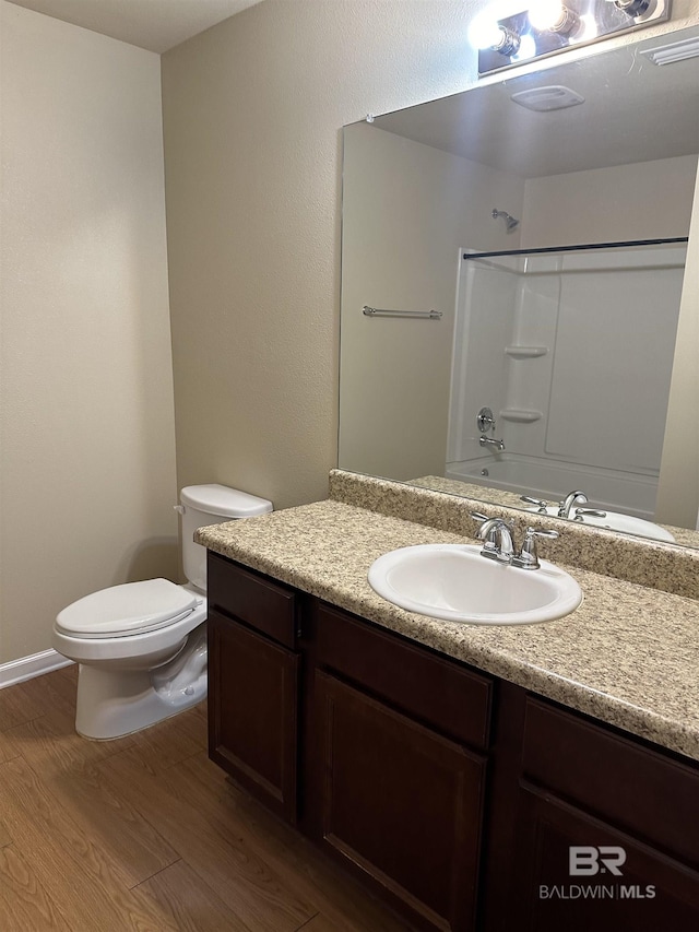 full bathroom with wood-type flooring, vanity, toilet, and shower / washtub combination