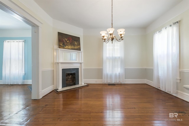 1206 Palmetto St, Mobile, AL 36604 - unfurnished living room with healthy amount of natural light, hardwood / wood-style flooring, a chandelier, and a fireplace with raised hearth