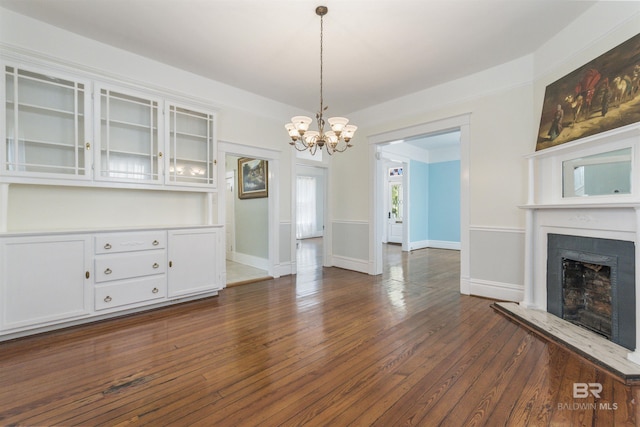 1206 Palmetto St, Mobile, AL 36604 - unfurnished living room with dark wood-style flooring, a fireplace with raised hearth, a chandelier, and baseboards