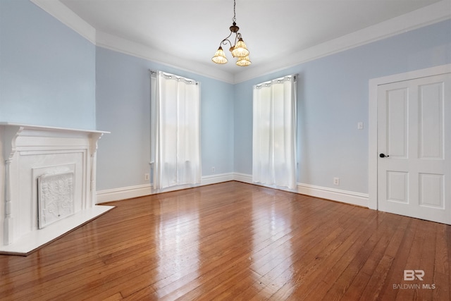 1206 Palmetto St, Mobile, AL 36604 - unfurnished living room with a chandelier, wood-type flooring, baseboards, crown molding, and a fireplace with flush hearth