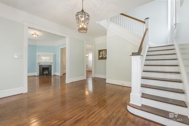 1206 Palmetto St, Mobile, AL 36604 - stairway featuring hardwood / wood-style flooring, a chandelier, baseboards, and a tile fireplace