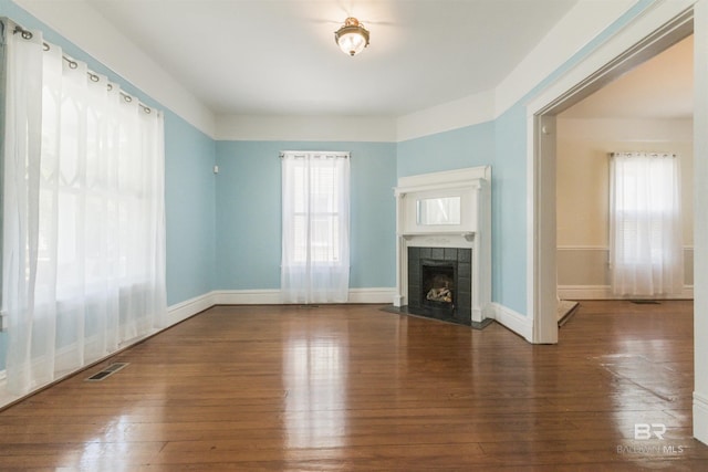 1206 Palmetto St, Mobile, AL 36604 - unfurnished living room with a fireplace, plenty of natural light, and hardwood / wood-style flooring