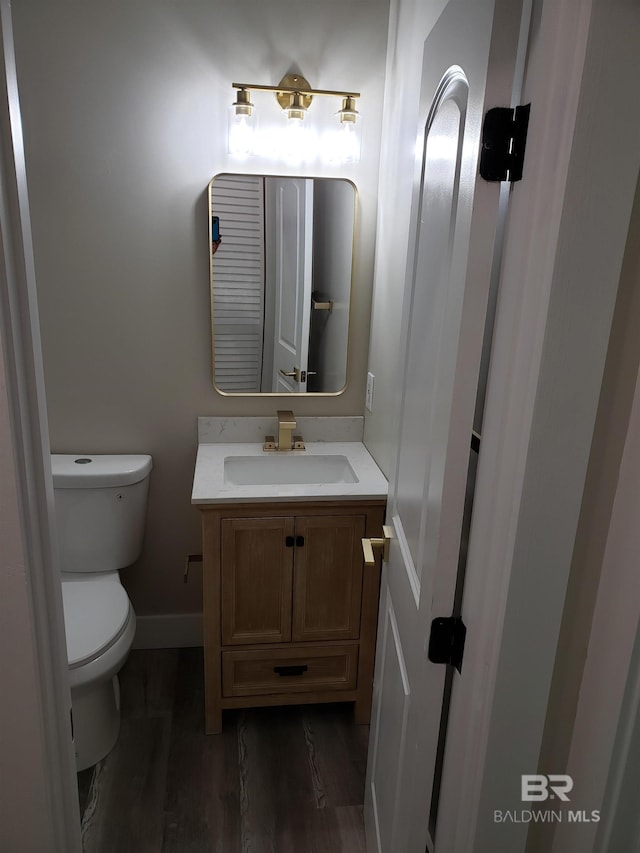 bathroom with vanity, toilet, and wood-type flooring