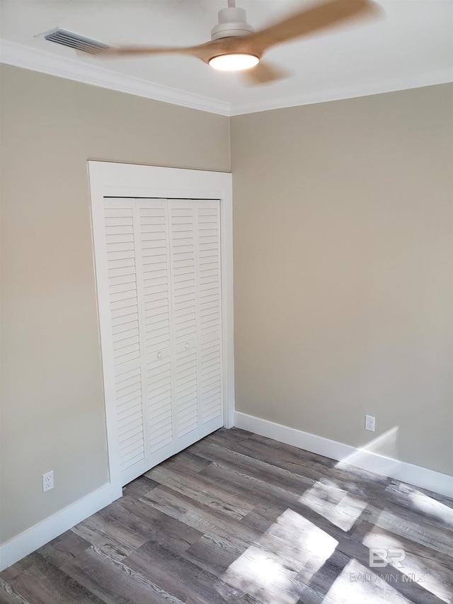 unfurnished bedroom featuring a closet, crown molding, hardwood / wood-style flooring, and ceiling fan