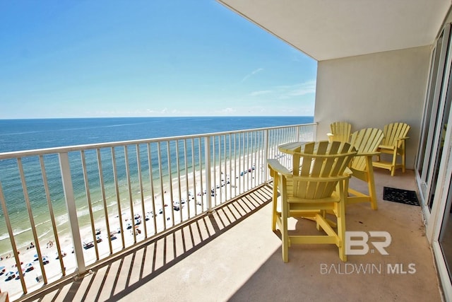 balcony featuring a water view and a beach view