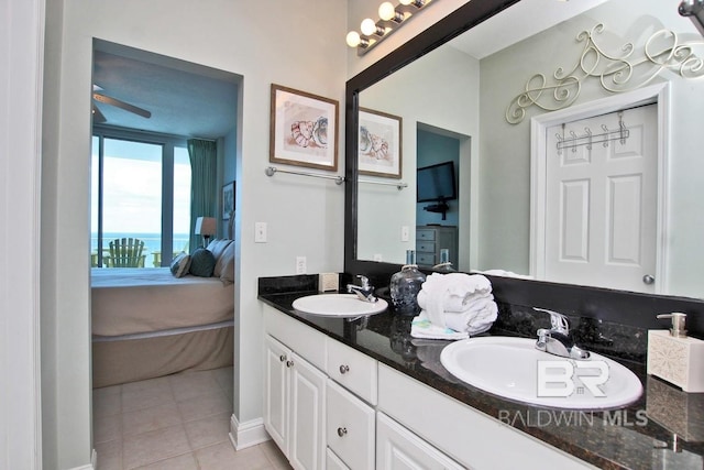 bathroom with double vanity, tile patterned floors, a sink, and connected bathroom