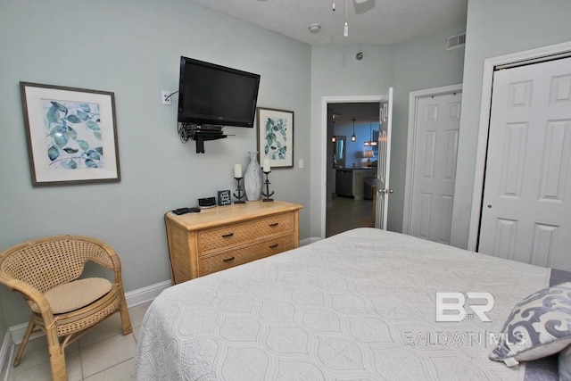 bedroom with tile patterned flooring, visible vents, and baseboards