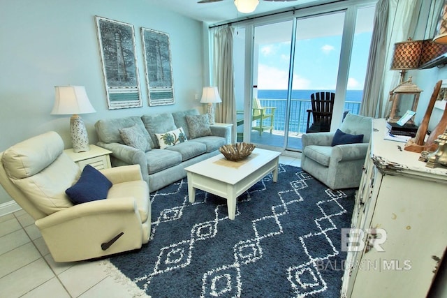 tiled living room featuring a water view and expansive windows