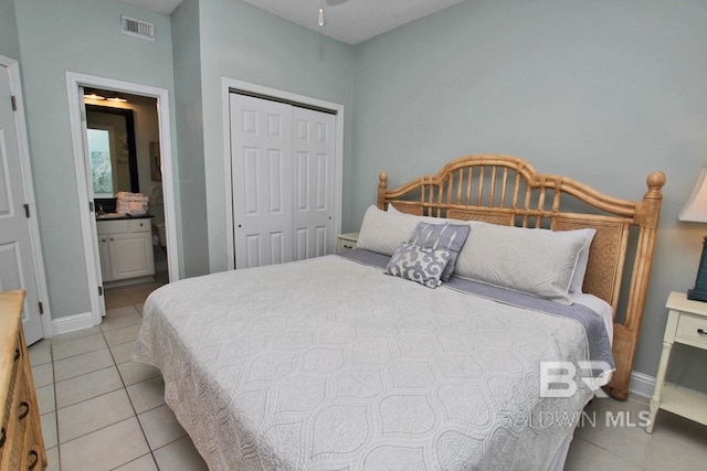 bedroom featuring light tile patterned floors, visible vents, baseboards, ensuite bath, and a closet