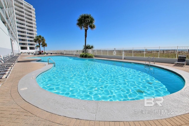 community pool featuring a patio and fence