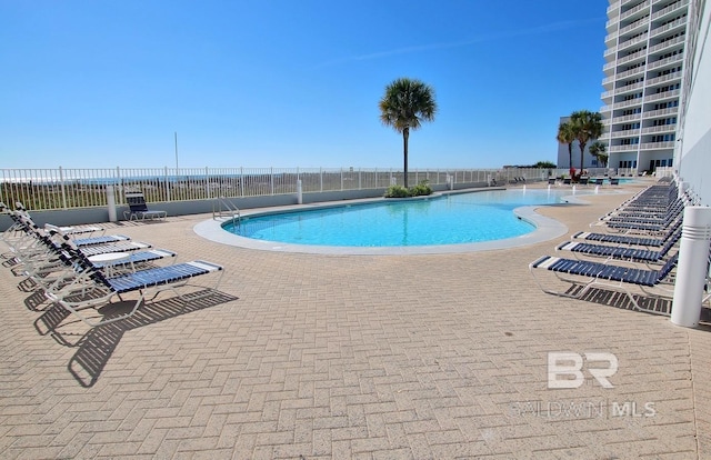 pool with a patio and fence