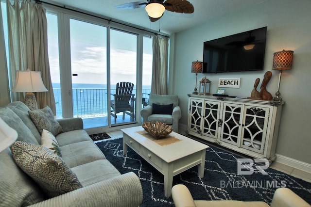 living room with ceiling fan, baseboards, and tile patterned floors