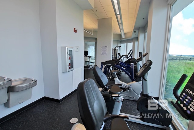 workout area with baseboards and a drop ceiling