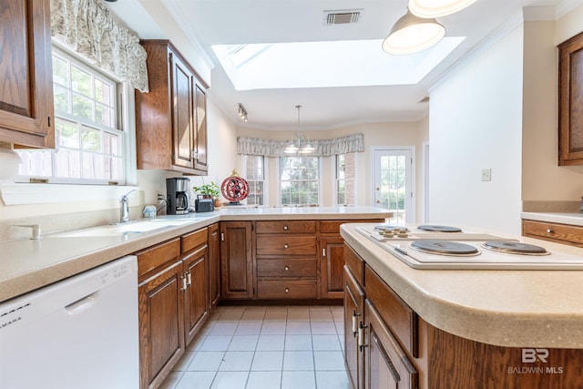 kitchen featuring visible vents, light countertops, a skylight, and white appliances