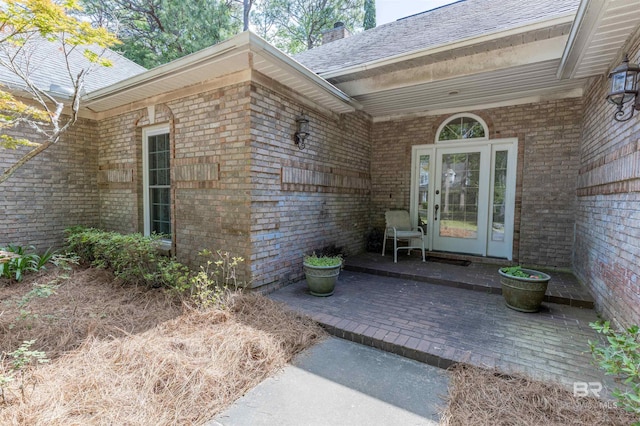 doorway to property with brick siding and a chimney