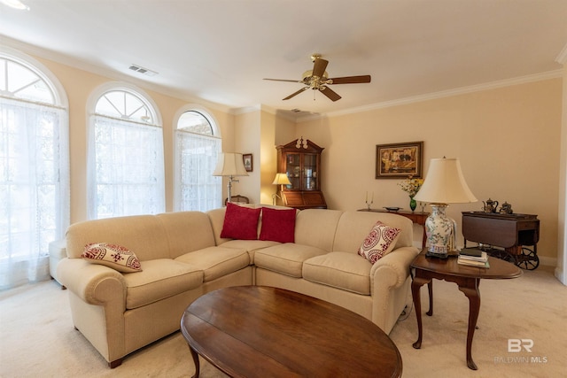 living area featuring ceiling fan, light colored carpet, ornamental molding, and visible vents