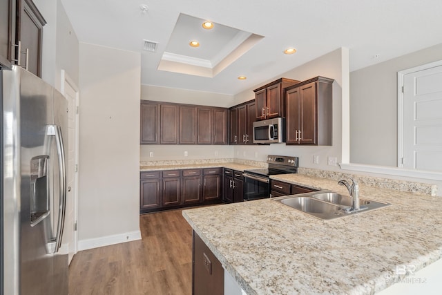 6877 Spaniel Dr Unit A, Spanish Fort, AL 36527 - kitchen featuring a tray ceiling, a sink, visible vents, light wood-style floors, and appliances with stainless steel finishes