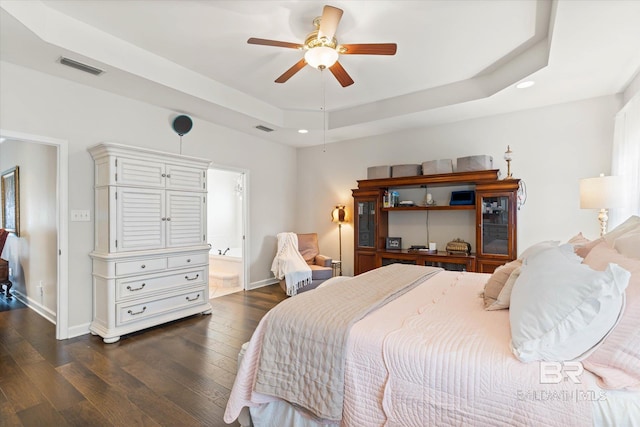 999 Weatherby St, Saraland, AL 36571 - bedroom featuring a tray ceiling, dark wood-type flooring, baseboards, recessed lighting, and ensuite bath