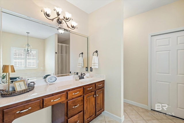 999 Weatherby St, Saraland, AL 36571 - bathroom with a chandelier, double vanity, tile patterned flooring, a shower, and baseboards