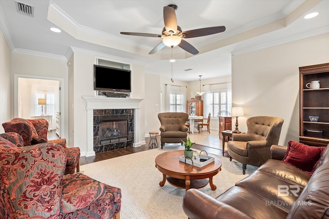 999 Weatherby St, Saraland, AL 36571 - living area with a tray ceiling, ceiling fan, a tile fireplace, ornamental molding, and wood finished floors