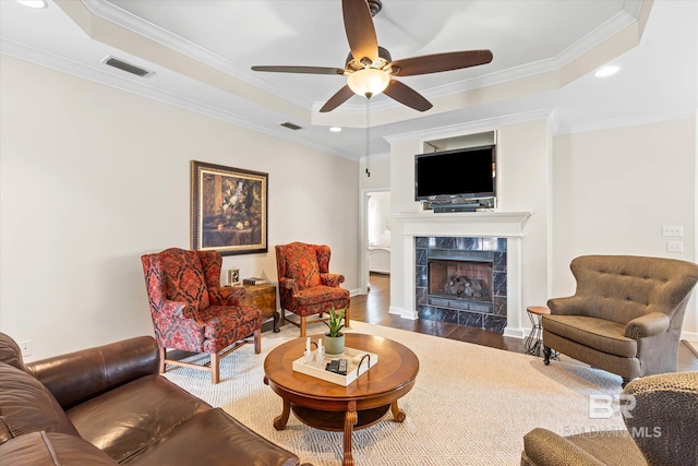 999 Weatherby St, Saraland, AL 36571 - living area featuring a tray ceiling, wood finished floors, ceiling fan, a fireplace, and crown molding