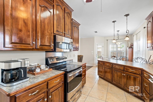 999 Weatherby St, Saraland, AL 36571 - kitchen featuring stainless steel appliances, light tile patterned floors, hanging light fixtures, baseboards, and a peninsula