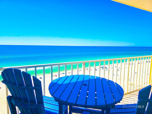 balcony featuring a beach view and a water view