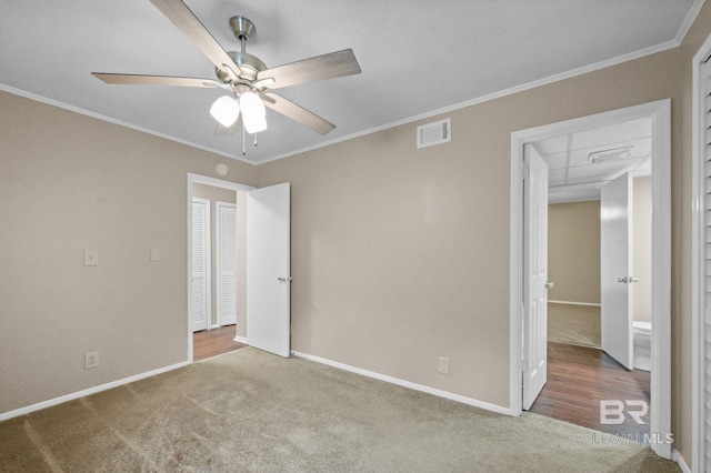 unfurnished bedroom featuring carpet flooring, ceiling fan, and crown molding