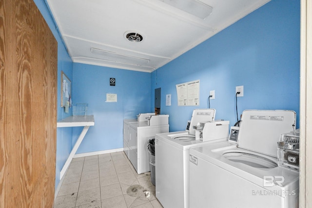 clothes washing area featuring washer and dryer, electric panel, and light tile patterned flooring