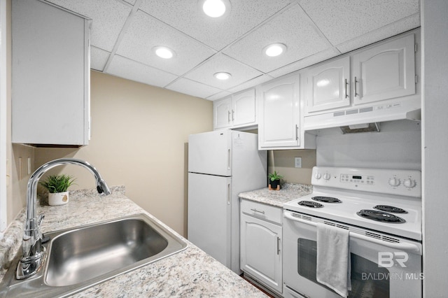 kitchen with white appliances, white cabinetry, a drop ceiling, and sink