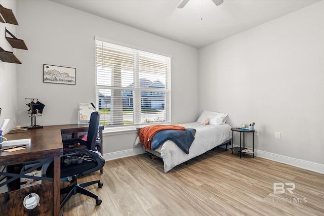 bedroom with light wood-type flooring, ceiling fan, and baseboards