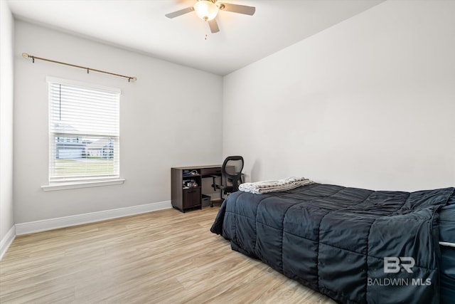 bedroom with ceiling fan, light wood-style flooring, and baseboards