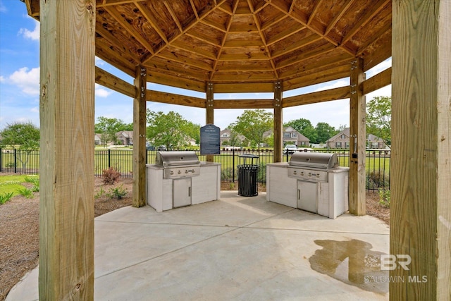 view of patio with a gazebo, fence, grilling area, and an outdoor kitchen