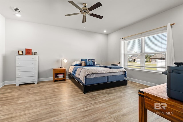 bedroom featuring visible vents, light wood-style flooring, and baseboards