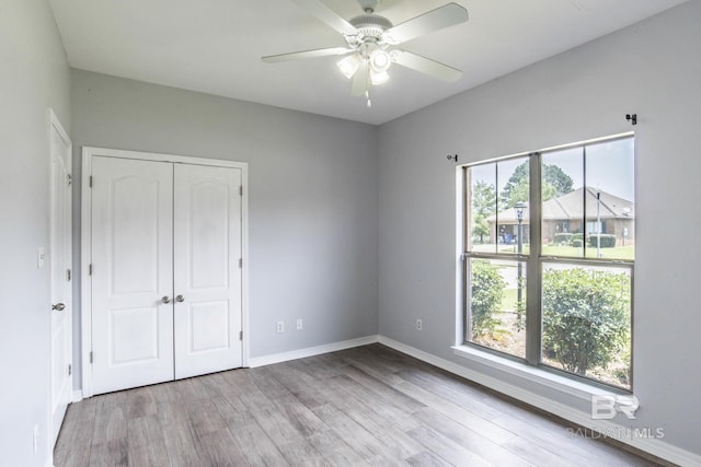 4005 Serene Ct, Foley, AL 36535 - unfurnished bedroom with multiple windows, wood finished floors, a closet, and baseboards