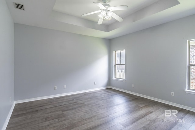 4005 Serene Ct, Foley, AL 36535 - spare room with visible vents, ceiling fan, baseboards, a tray ceiling, and dark wood-style floors