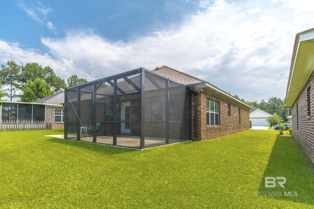 4005 Serene Ct, Foley, AL 36535 - rear view of property featuring glass enclosure, a patio, a lawn, and brick siding