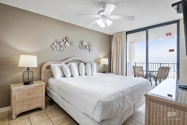 bedroom with a textured ceiling, light tile patterned flooring, and ceiling fan