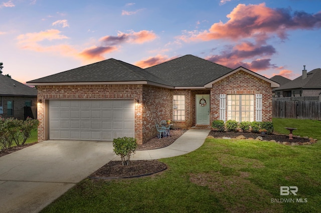 view of front of property with a garage and a lawn