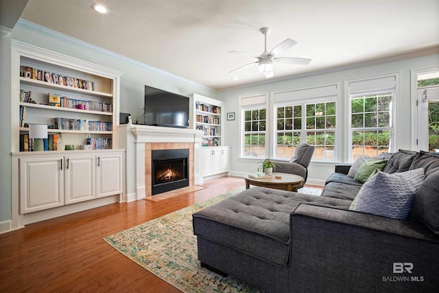 14 General Canby Dr, Spanish Fort, AL 36527 - living area featuring a fireplace, wood finished floors, a ceiling fan, plenty of natural light, and crown molding