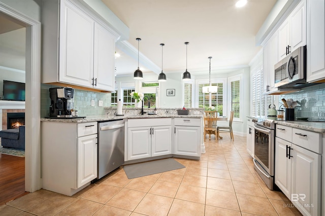 14 General Canby Dr, Spanish Fort, AL 36527 - kitchen featuring appliances with stainless steel finishes, crown molding, decorative backsplash, white cabinetry, and a peninsula