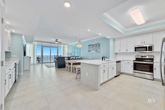 kitchen featuring stainless steel appliances, ornamental molding, a sink, and decorative backsplash