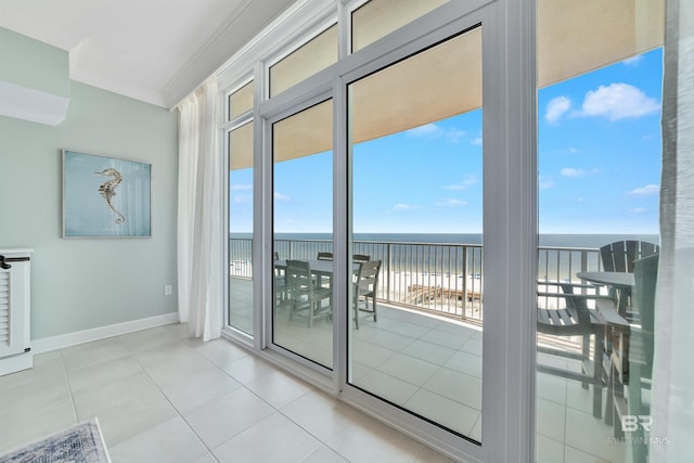 doorway to outside with a beach view, baseboards, ornamental molding, a water view, and tile patterned flooring