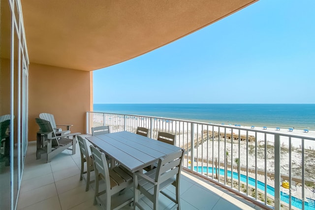 balcony with a water view and a view of the beach