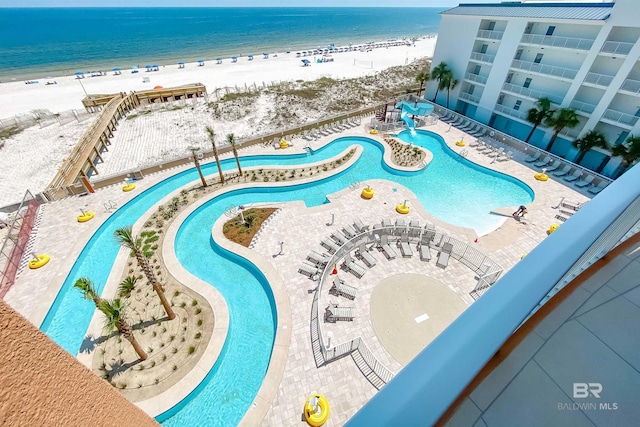 community pool with a view of the beach and a water view