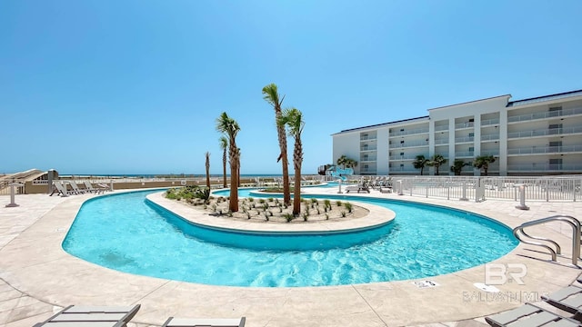 community pool featuring fence and a patio